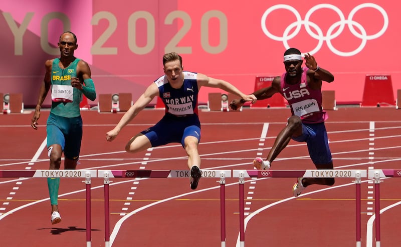 Karsten Warholm, of Norway, center, clears a hurdle before winning the gold medal ahead of Rai Benjamin, of United States in the final of the men's 400-meter hurdles at the 2020 Summer Olympics, Tuesday, Aug. 3, 2021, in Tokyo, Japan. At left is Alison Dos Santos, of Brazil who took the bronze.