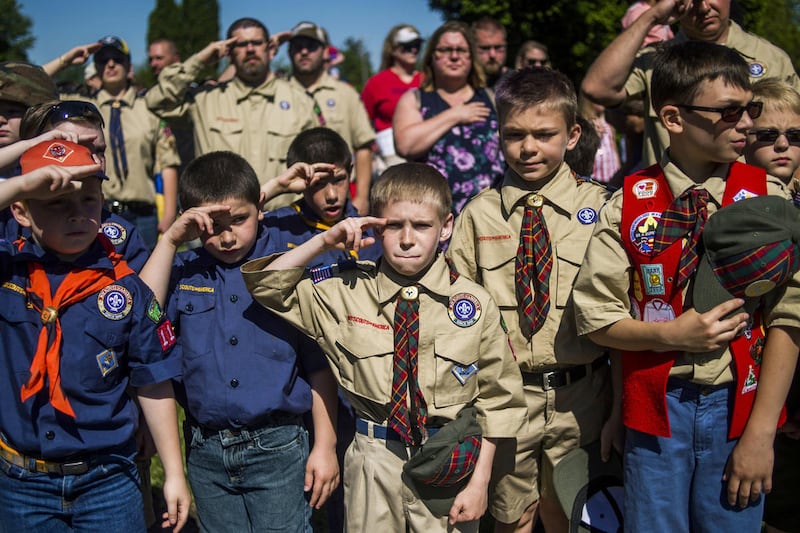 FILE - In this Monday, May 29, 2017 file photo, Boy Scouts and Cub Scouts salute during a Memorial Day ceremony in Linden, Mich. On Wednesday, Oct. 11, 2017, the Boy Scouts of America Board of Directors unanimously approved to welcome girls into its Cub S