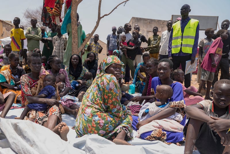 South Sudanese who fled from Sudan sit outside a nutrition clinic at a transit center in Renk, South Sudan, on May 16, 2023.