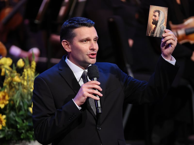 Derrick Porter holds a picture of Jesus Christ during his first broadcast of "Music & the Spoken Word" with the Tabernacle Choir and Orchestra at Temple Square at the Conference Center in Salt Lake City.