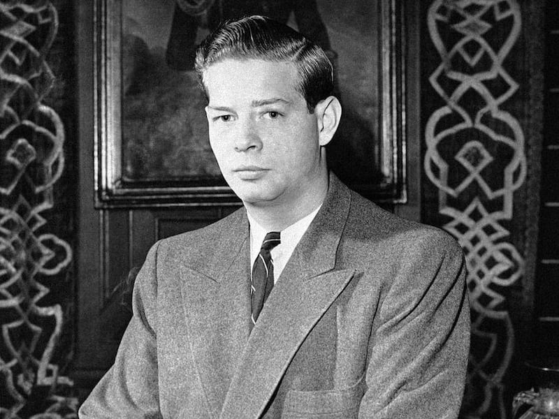 FILE - This is a on December 8, 1946 file photo of  King Michael I of Romania, son of Ex-King Carol I and Queen Helen as he holds a cigarette while posing for a portrait  at Peles Castle in Romania. One person attending Britain's royal wedding has seen it