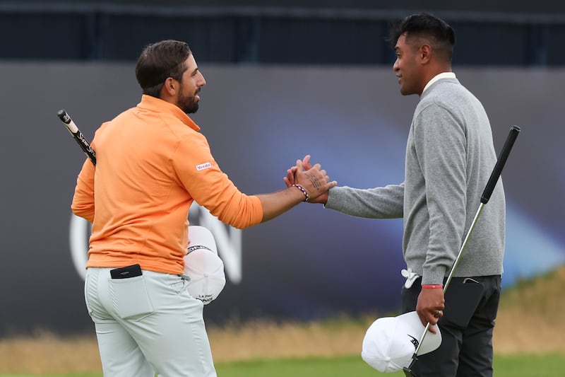Matthieu Pavon of France, left, and Tony Finau of the United States shakes hands on the 18th green following their second round of the British Open Golf Championships at Royal Troon golf club in Troon, Scotland, Friday, July 19, 2024.