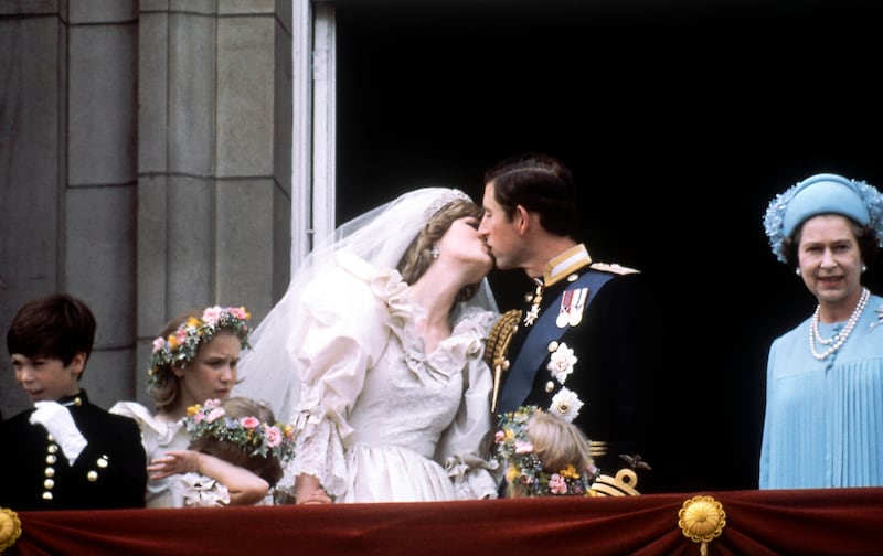 Princess Diana and Prince Charles share a wedding kiss while Queen Elizabeth II stands by