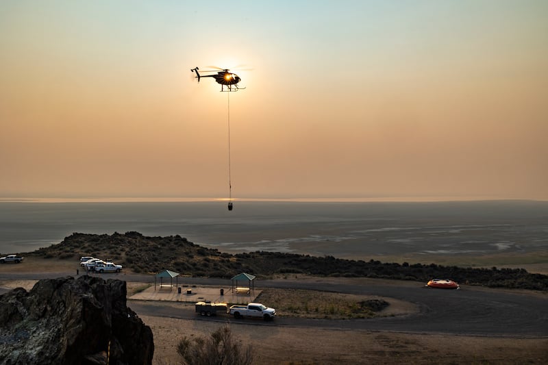 A helicopter dips water to fill six remote guzzlers at Antelope Island State Park for the island’s bighorn sheep.